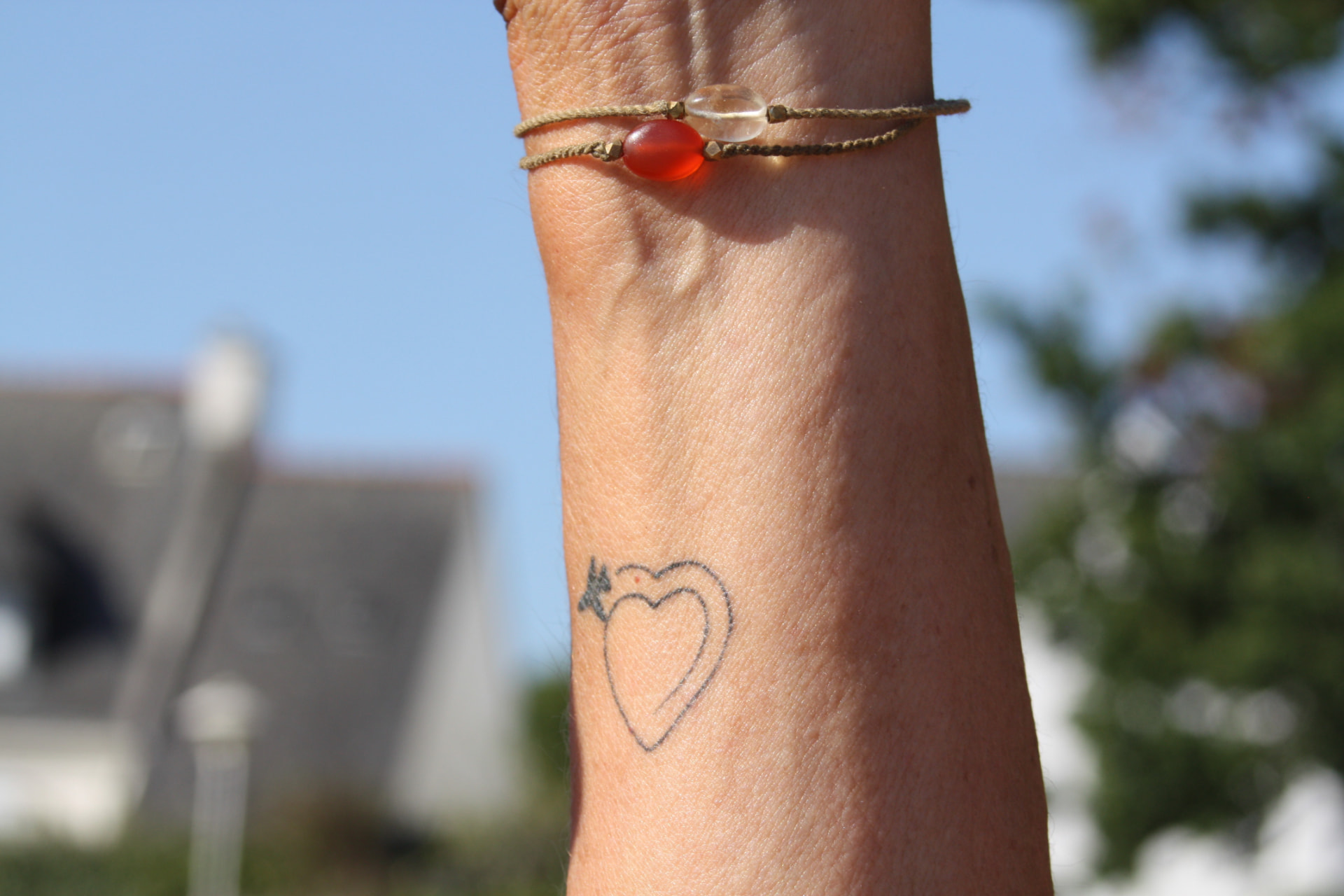 Bracelet et tatouage cœur au poignet