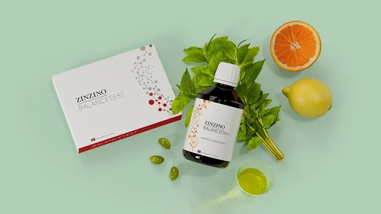 Coffret Zinzino BalanceTest et flacon de BalanceOil+ saveur orange citron menthe, entourés de menthe fraîche, d’une demi-orange, d’un citron et de gélules, sur fond vert d’eau